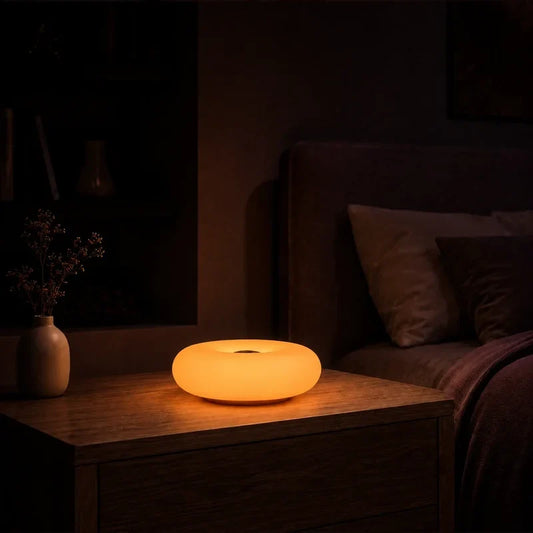 Lampe galet ovale lumineux allumée dans une chambre adulte chaleureuse.