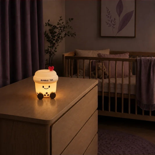 Veilleuse en forme de bubble tea allumée sur une commode dans une chambre de bébé.