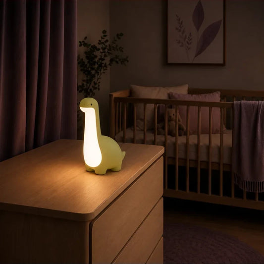 Veilleuse en forme de dinosaure vert à long cou allumée sur une commode dans une chambre de bébé.