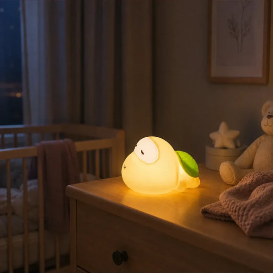 Veilleuse tortue endormie allumée sur une commode dans une chambre de bébé.