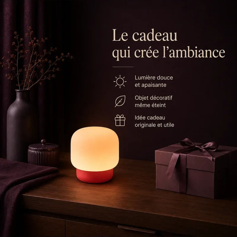 Lampe arrondie avec base rouge présentée dans une ambiance cadeau.