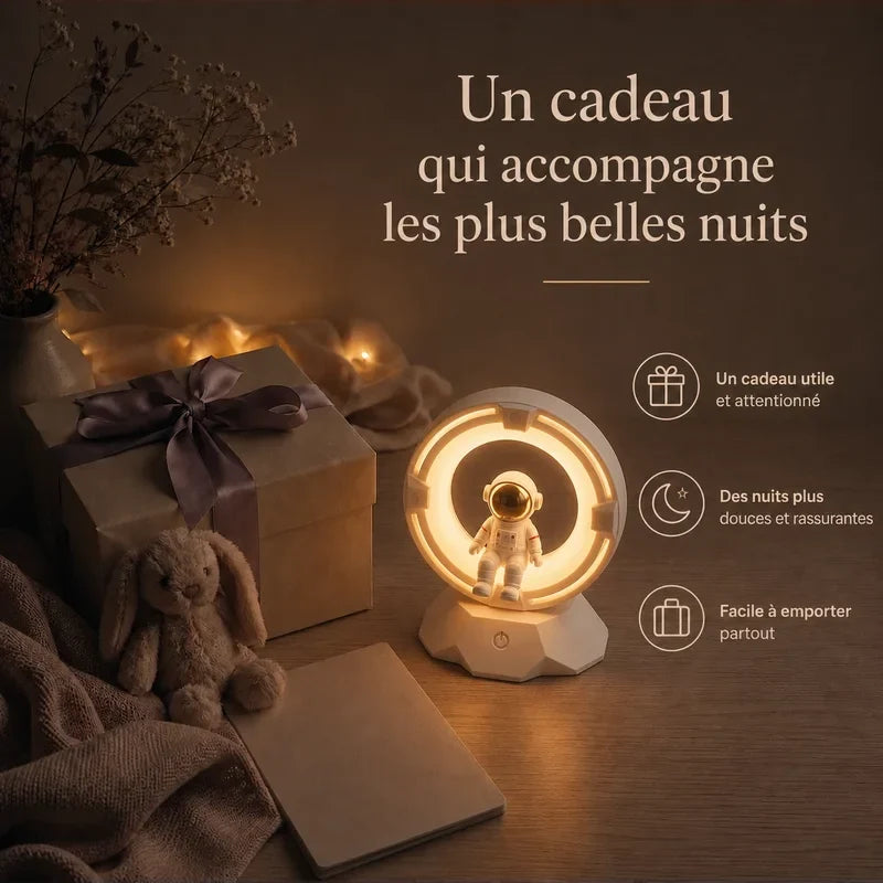 Veilleuse en forme d’astronaute dans un anneau lumineux présentée dans une ambiance cadeau avec une boîte et un ruban.