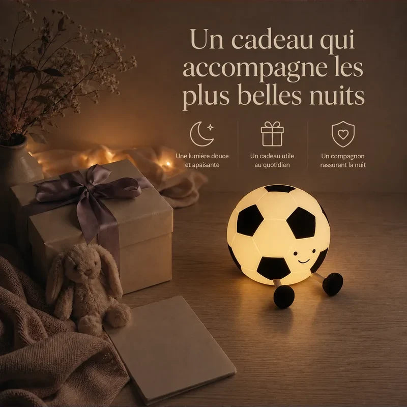 Veilleuse en forme de ballon de football présentée dans une ambiance cadeau avec une boîte et un ruban.