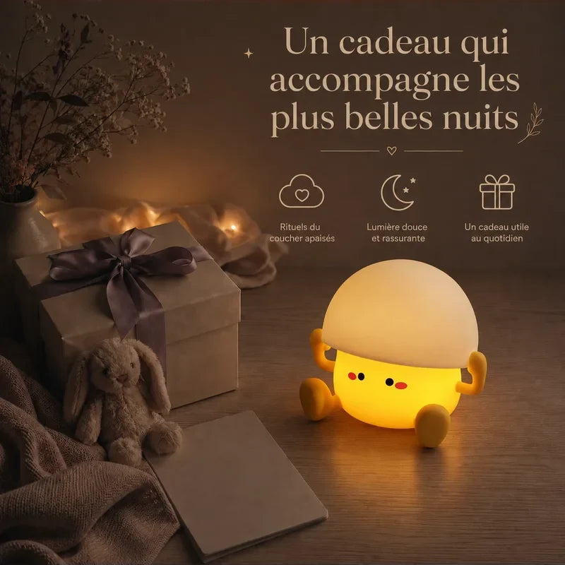 Veilleuse en forme de champignon assis présentée dans une ambiance cadeau avec une boîte et un ruban.
