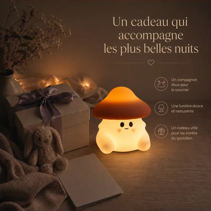 Veilleuse en forme de champignon orange présentée dans une ambiance cadeau avec une boîte et un ruban.