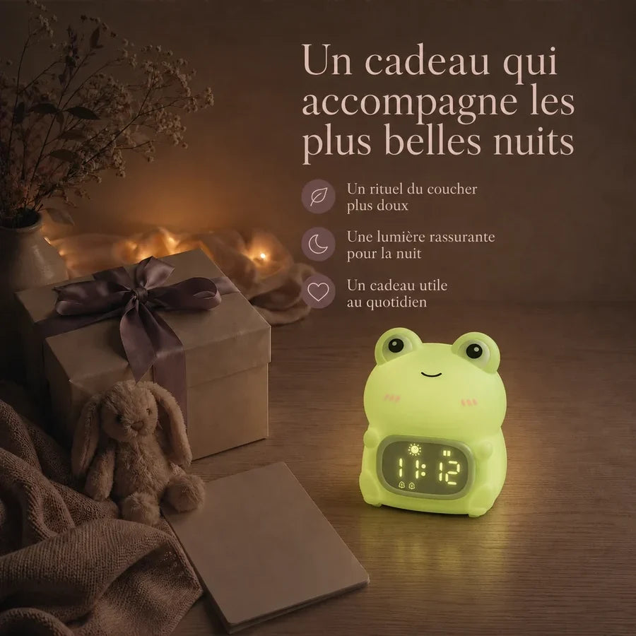 Veilleuse réveil en forme de grenouille présentée dans une ambiance cadeau avec une boîte et un ruban.