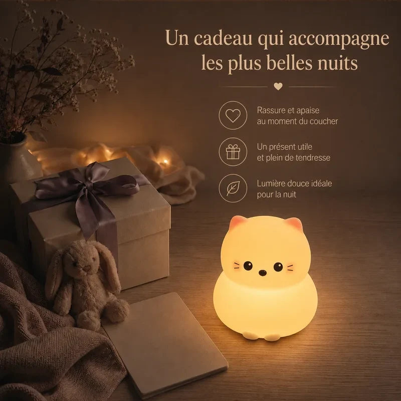 Veilleuse en forme de chat rond présentée dans une ambiance cadeau avec une boîte et un ruban.