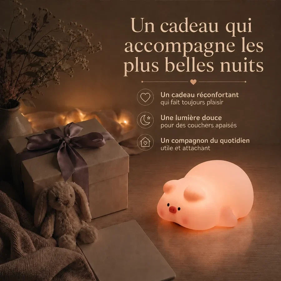 Veilleuse en forme de cochon endormi présentée dans une ambiance cadeau avec une boîte et un ruban.