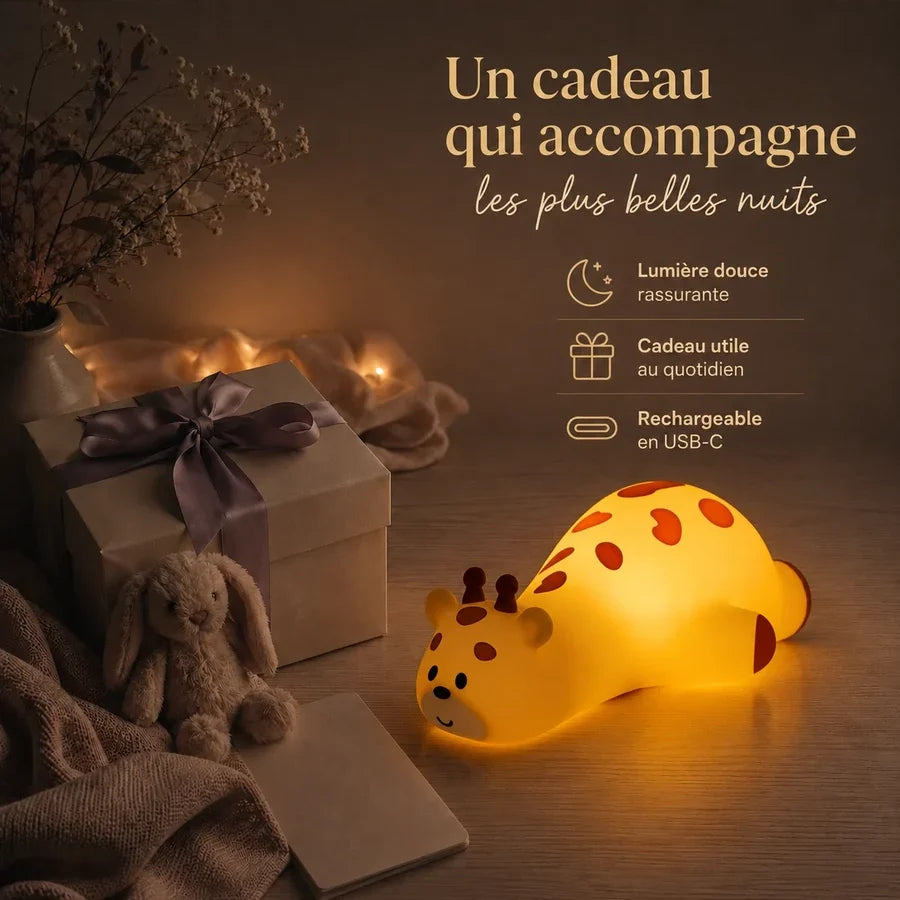 Veilleuse en forme de girafe allongée présentée dans une ambiance cadeau avec une boîte et un ruban.