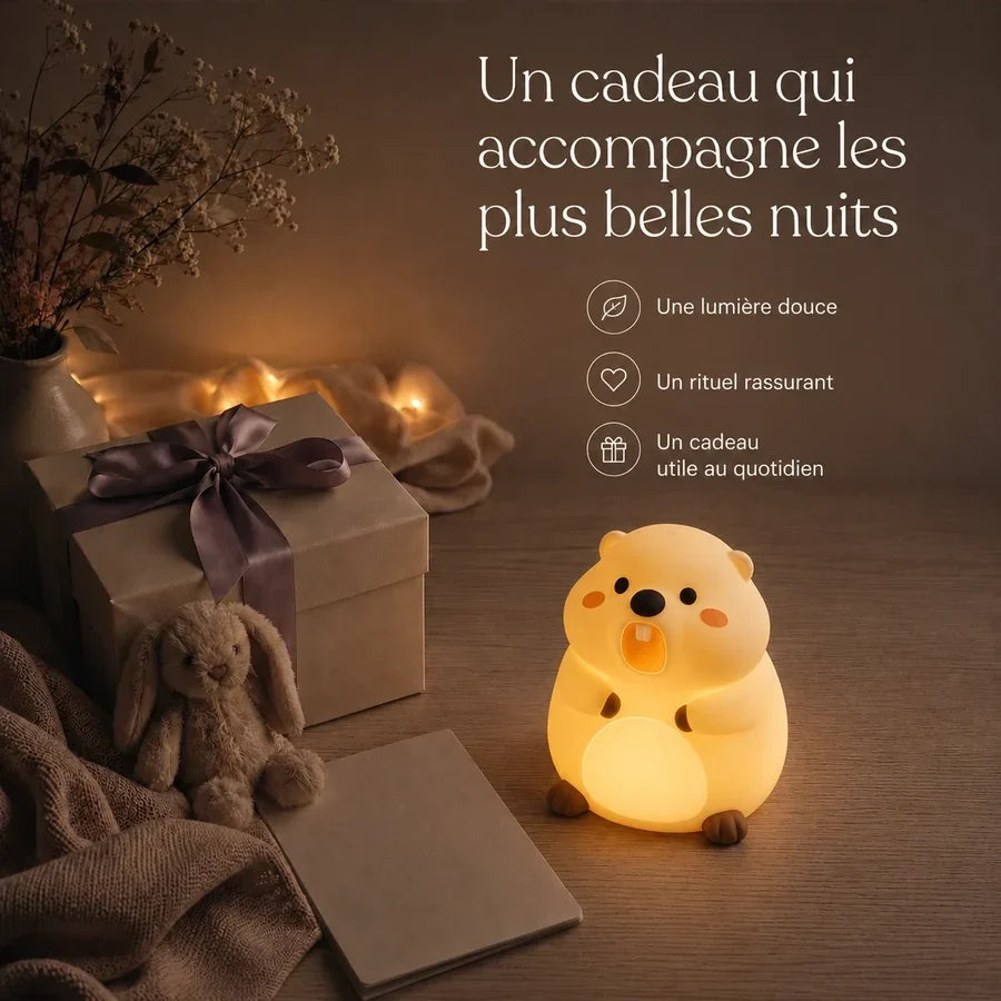 Veilleuse en forme de marmotte présentée dans une ambiance cadeau avec une boîte et un ruban.