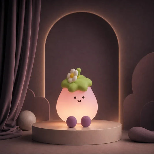 Veilleuse en forme d’aubergine souriante allumée sur un podium mauve.