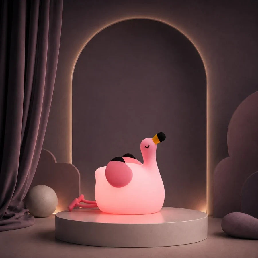 Veilleuse en forme de flamant rose allumée sur un podium mauve.