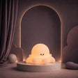 Veilleuse en forme de poulpe allumée sur un podium mauve.