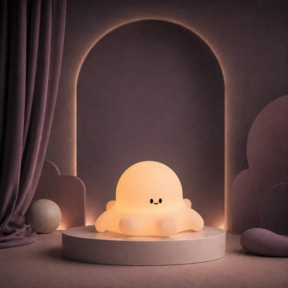 Veilleuse en forme de poulpe allumée sur un podium mauve.