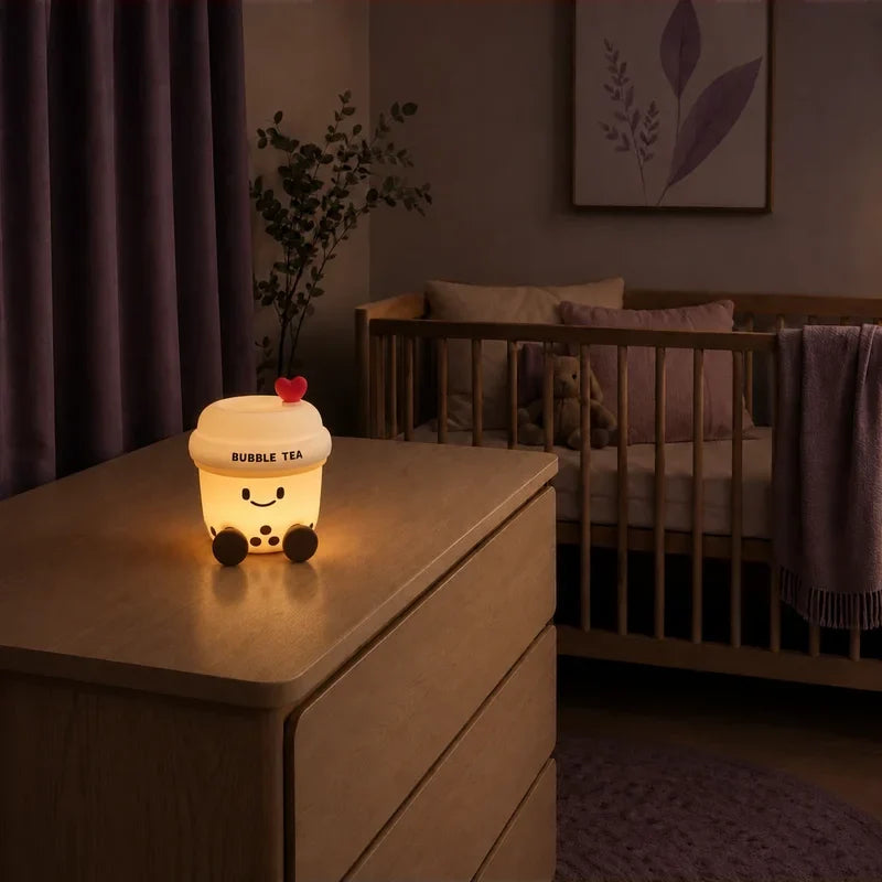 Veilleuse en forme de bubble tea allumée sur une commode dans une chambre de bébé.