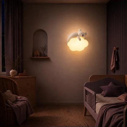Veilleuse murale nuage avec ourson allumée dans une chambre de bébé.