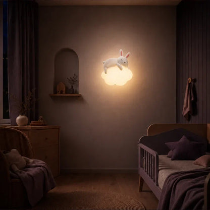 Veilleuse murale nuage et lapin allumée dans une chambre de bébé.