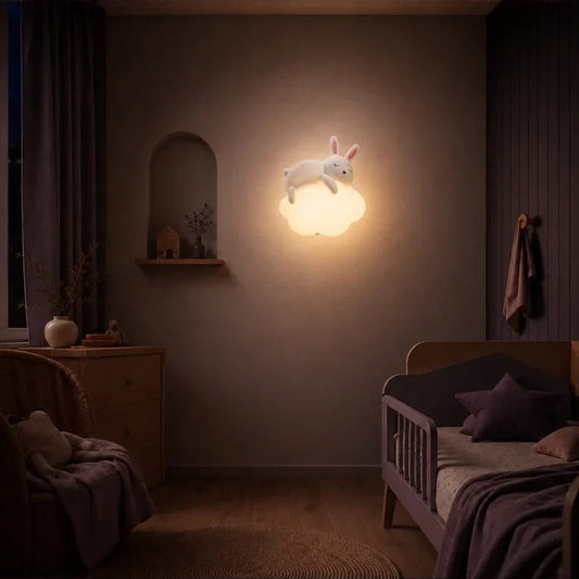 Veilleuse murale nuage et lapin allumée dans une chambre de bébé.