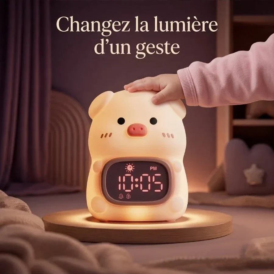 Main d’enfant touchant la veilleuse réveil en forme de cochon pour changer la lumière.