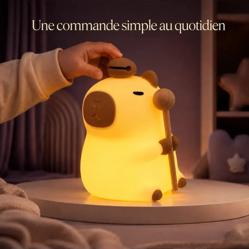 Main touchant la veilleuse en forme de capybara debout pour changer la lumière.