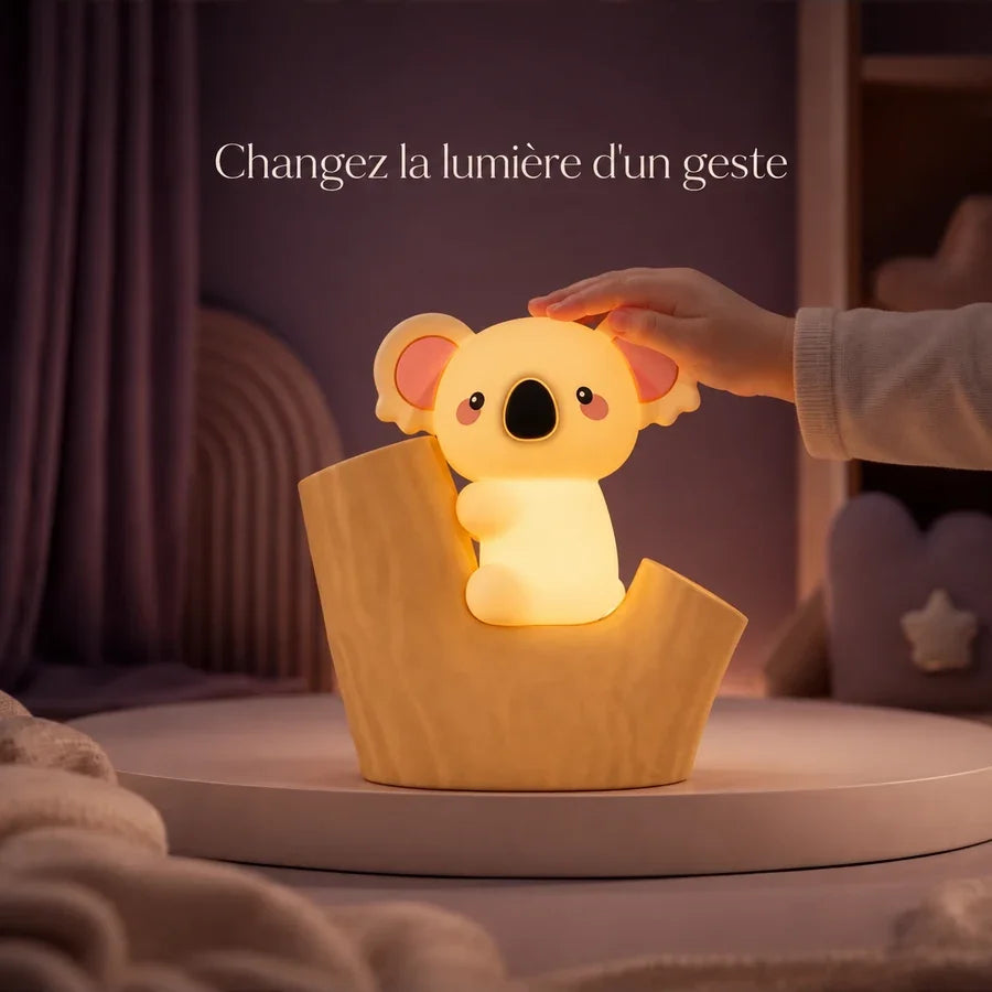 Main d’enfant touchant la veilleuse koala installée dans une souche pour changer la lumière.