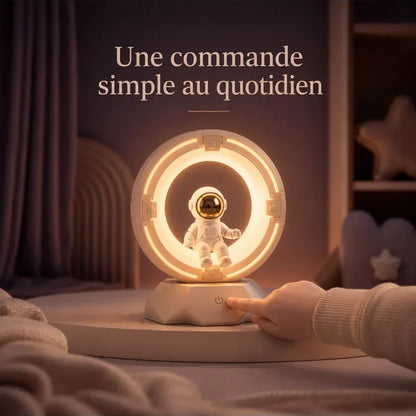 Main touchant la veilleuse en forme d’astronaute dans un anneau lumineux pour changer la lumière.