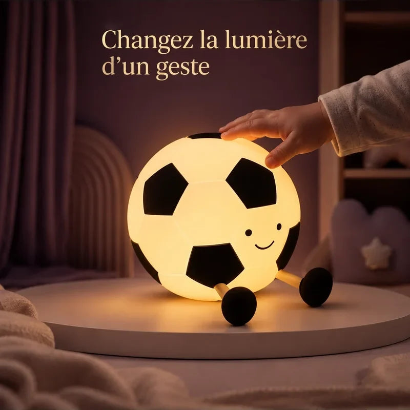 Main touchant la veilleuse en forme de ballon de football pour changer la lumière.
