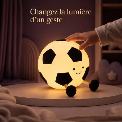 Main touchant la veilleuse en forme de ballon de football pour changer la lumière.