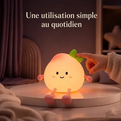 Main touchant la veilleuse en forme de pêche souriante pour changer la lumière.