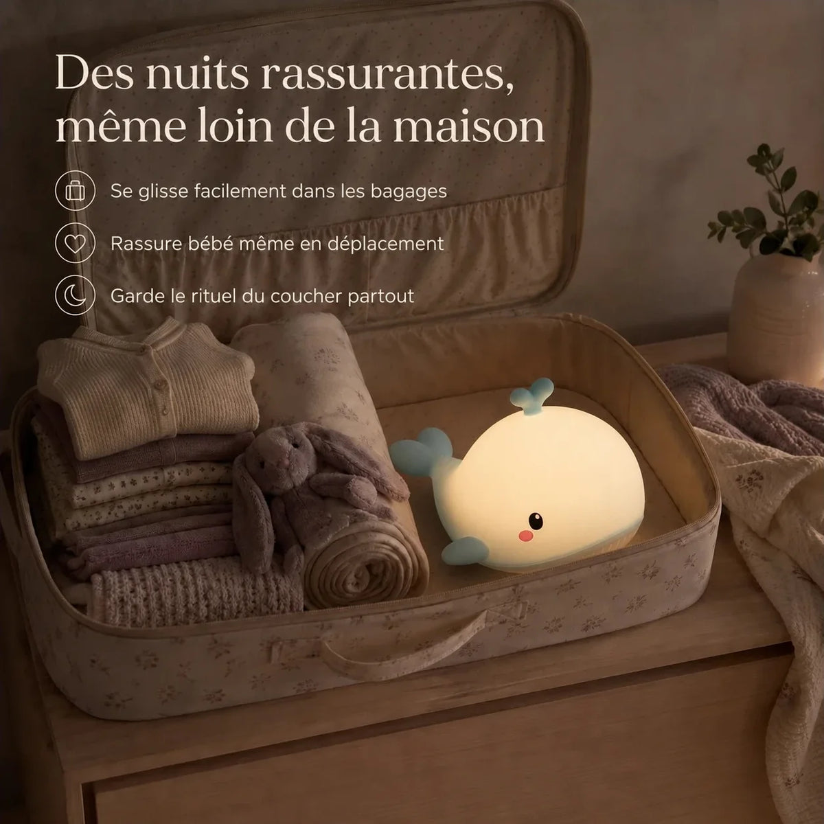 Veilleuse en forme de baleine bleue rangée dans une valise pour accompagner un enfant en voyage.