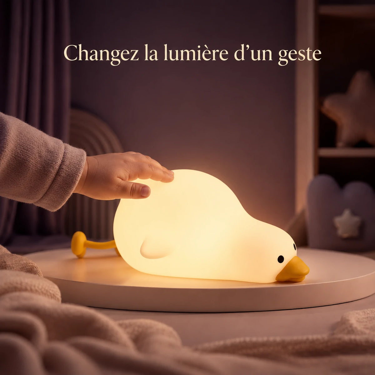 Main touchant la veilleuse en forme de canard allongé pour changer la lumière.